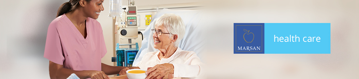 Health care. Nurse with elderly patient having a soup in a hospital bed.